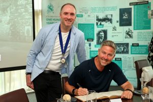 July 2026 event - Guest Speaker Charlie Wardle - The Mountain Coach signing the guest speaker book, with NCBC President Joe Burns of Reformed IT.