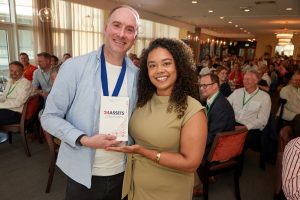 July 2026 event -NCBC President Joe Burns of Reformed IT presents a business book to Lydia Elliott-Johnson Buckles Solicitors LLP - A business book is given to the 24th person to book on the event - A nod to the NCBC being created in 1924
